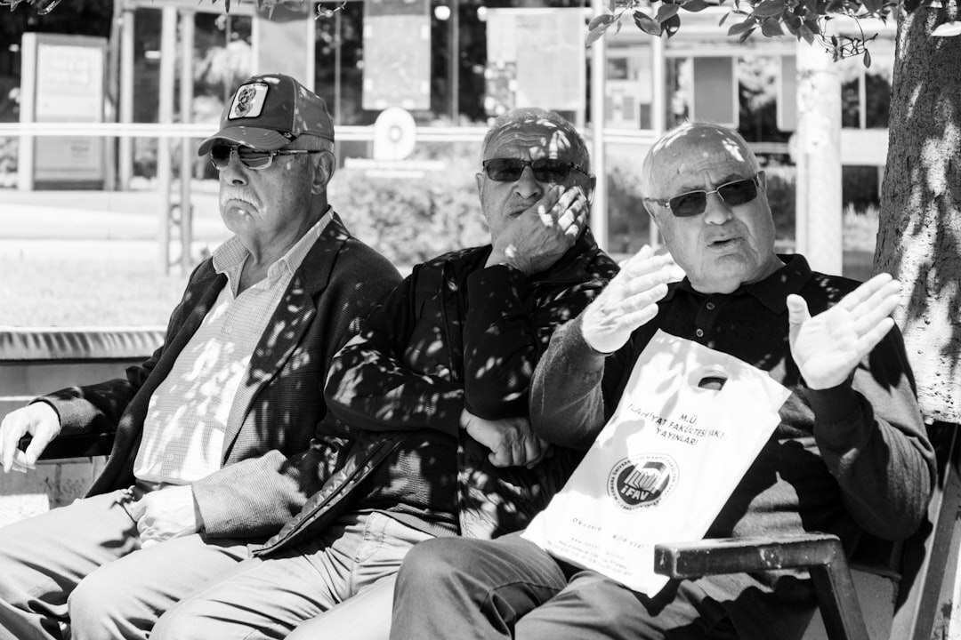 Three cheerful seniors looking at a photo album together and laughing